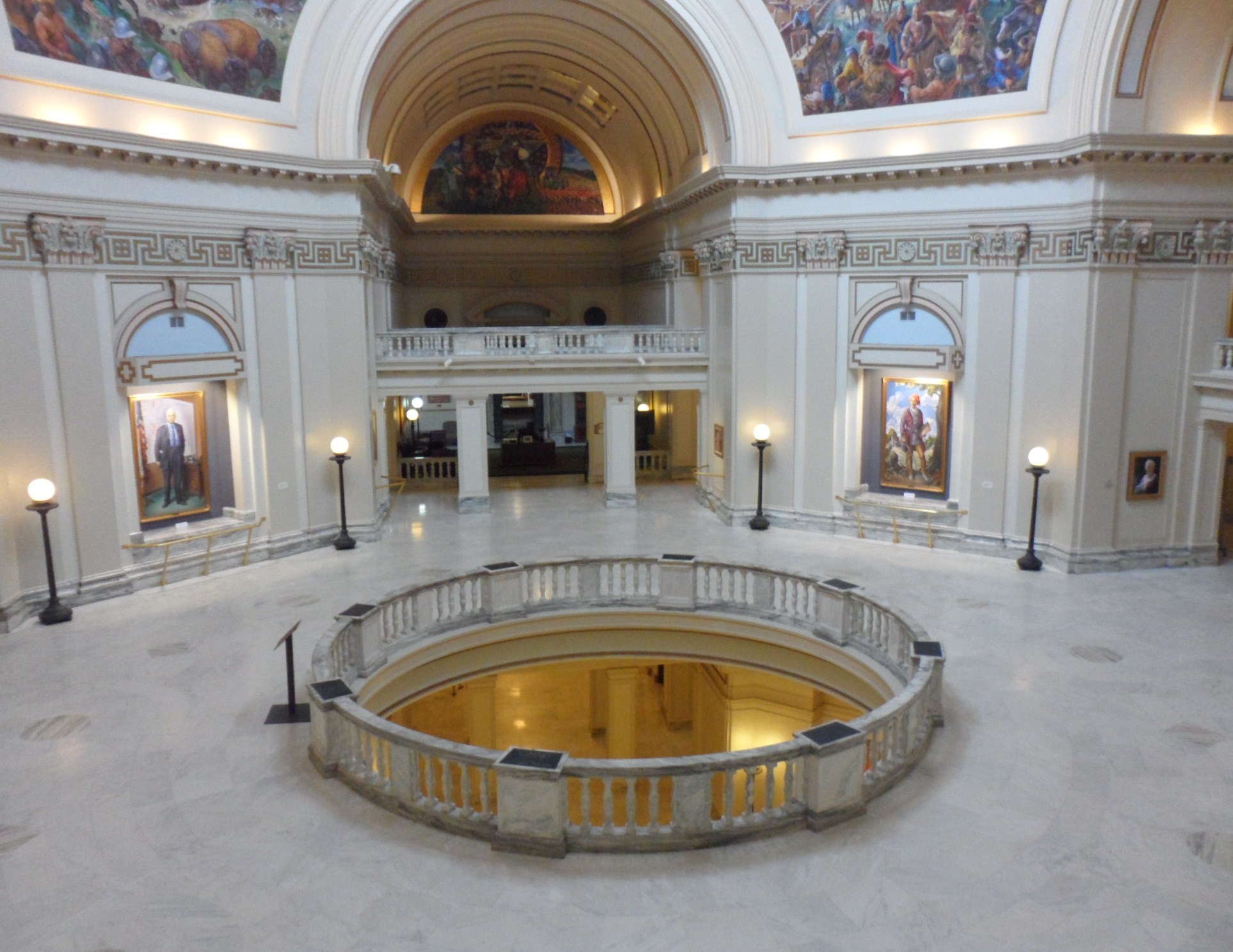On both this picture and then next, the paintings on top depict Oklahoma at different time periods and the bottom portraits are famous Oklahomians.
