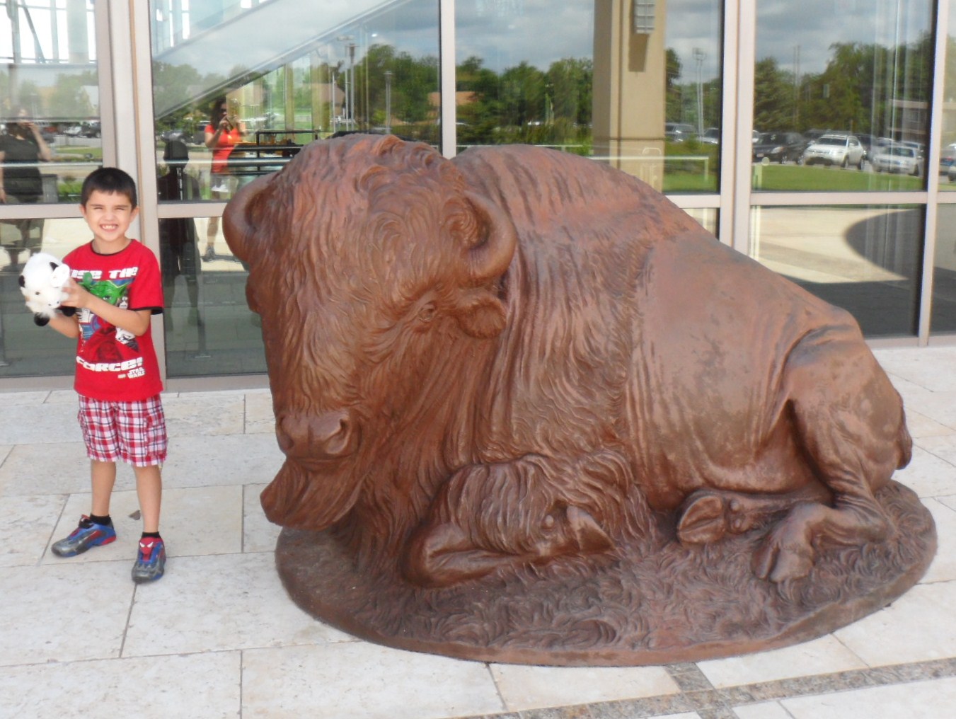 Connor wanted to take a picture by himself with his bison that he had just bought from the gift shop.