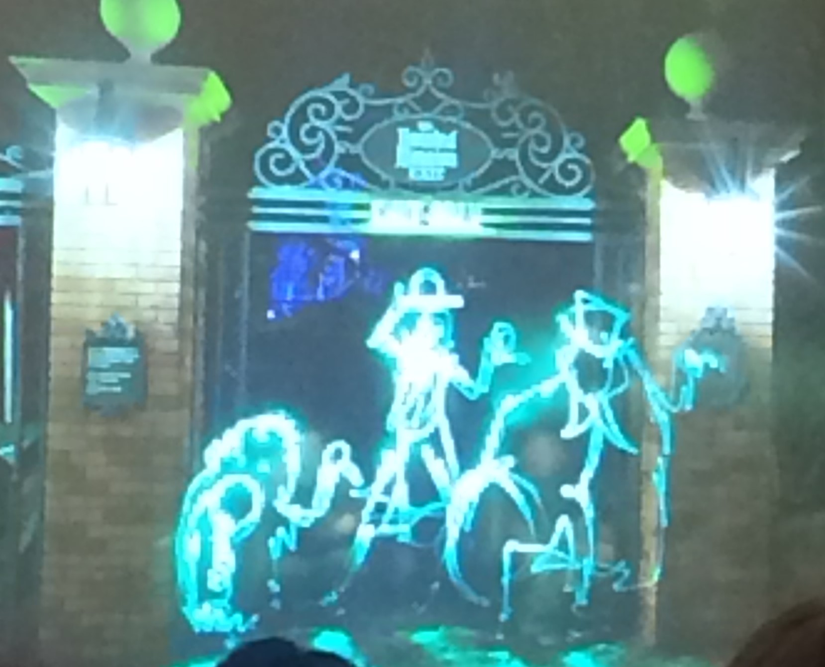 A light painting of the Hitchhiking Ghosts in front of The Haunted Mansion.